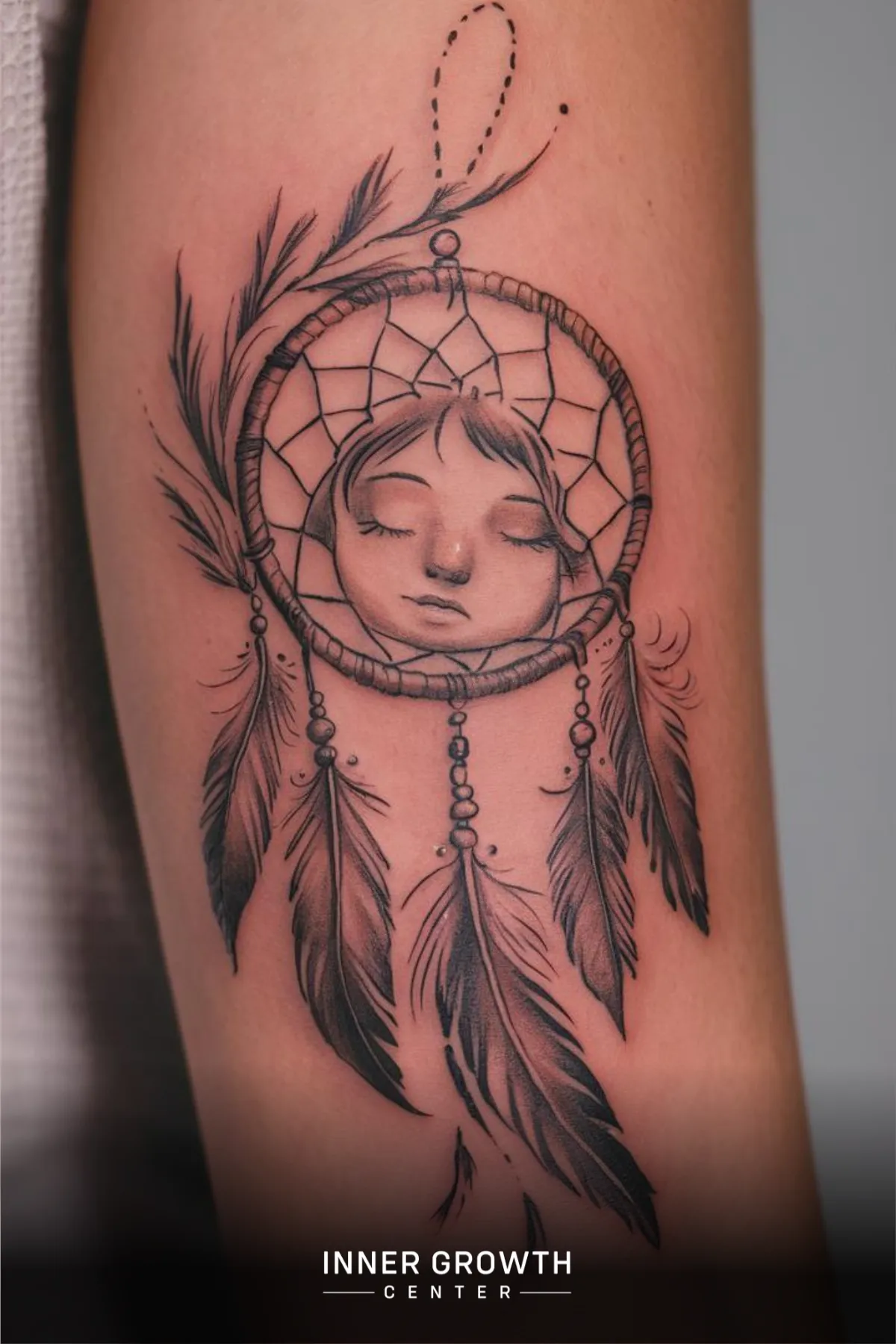 A dreamcatcher tattoo with a girls face.